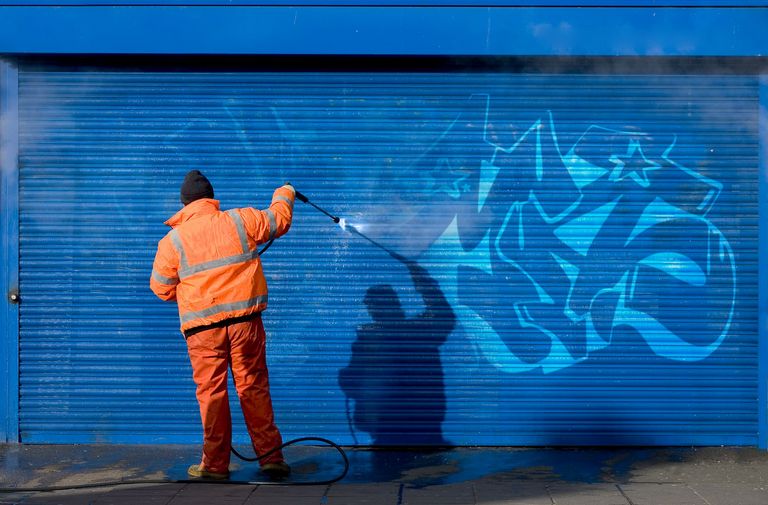 Guy cleaning graffiti